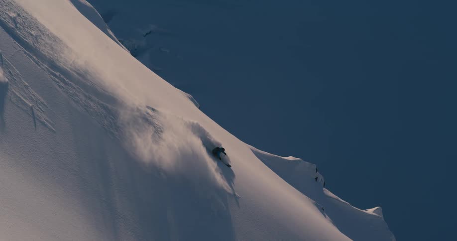 A person skiing down a mountain covered in fresh snow