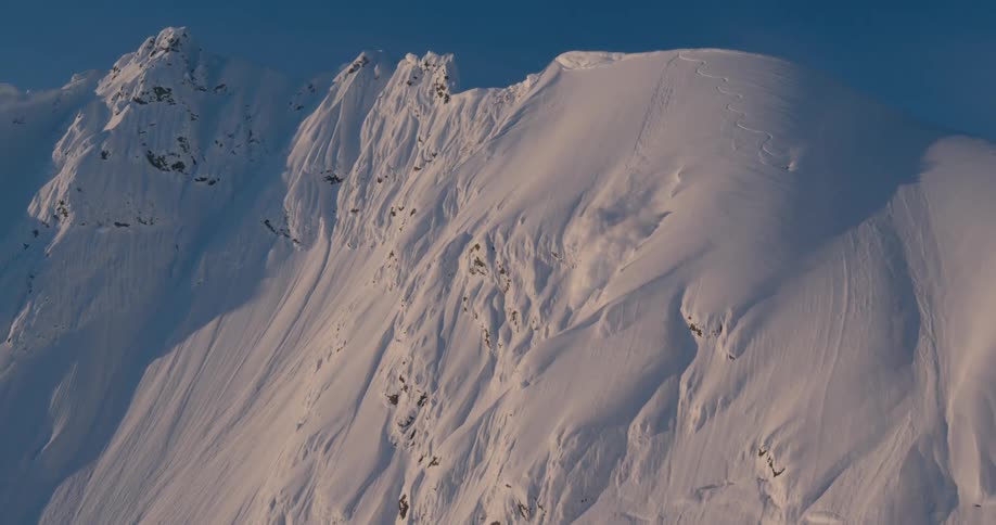 An aerial view of a mountain in winter is displayed