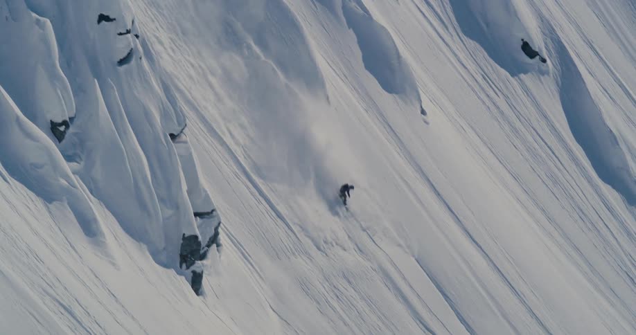 A person snowboarding down a mountain with snow and ice