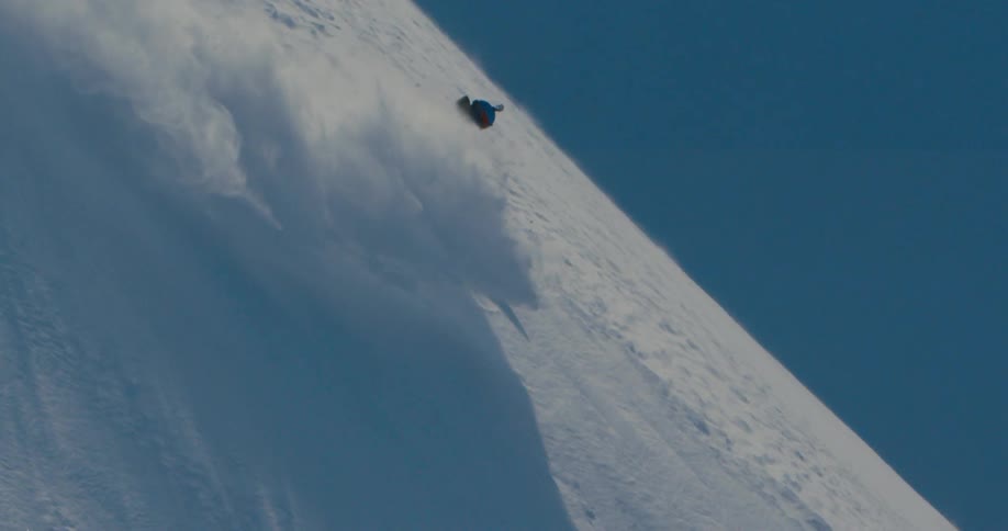 Downhill skiier on steep mountain slope