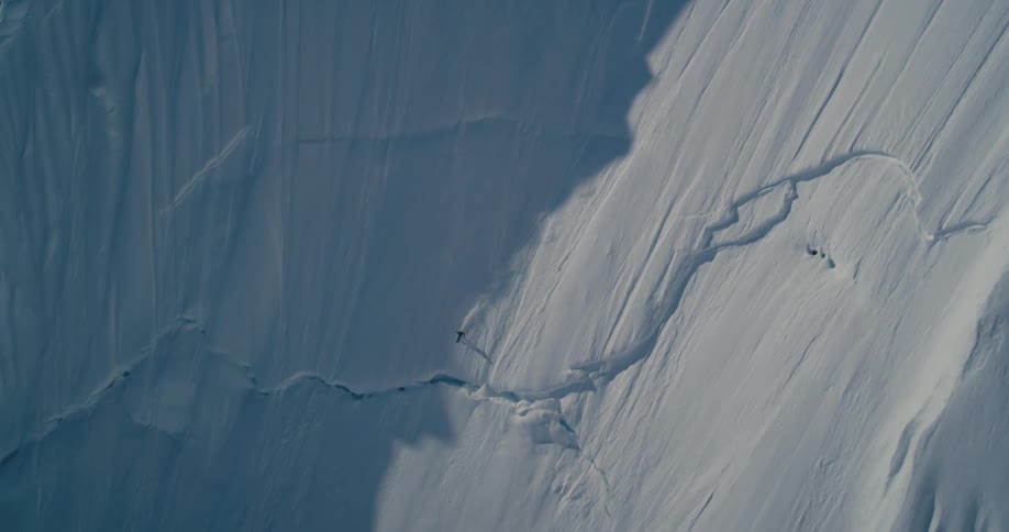 A person skiing down a large snow covered mountain