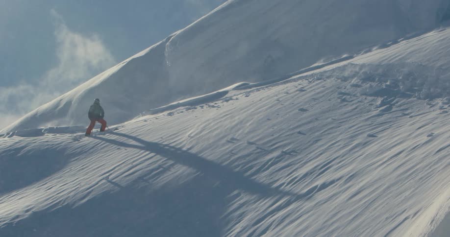 A man is hiking up the snow covered mountain