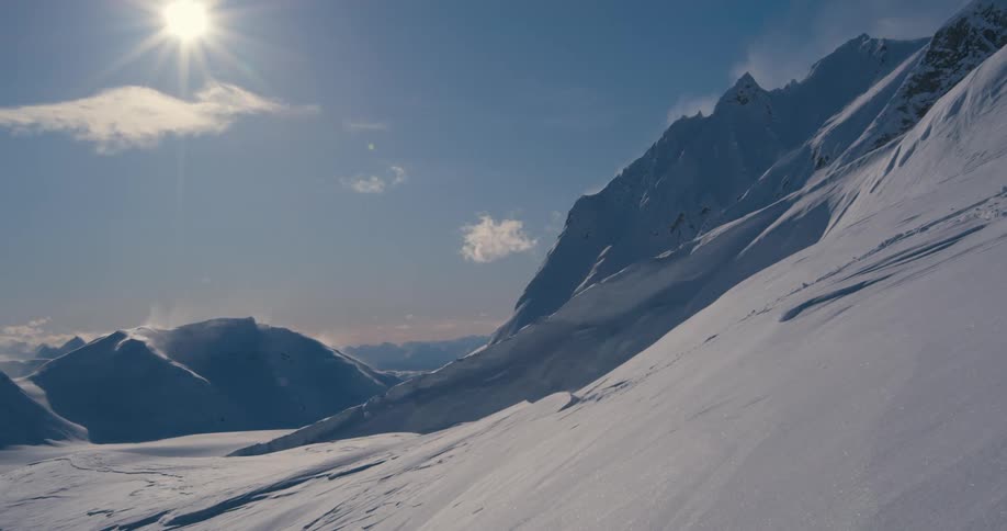 Snow covered slopes of a mountain range at day