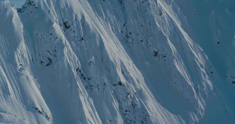 Skier slides down from the mountain peak to the base of the mountain