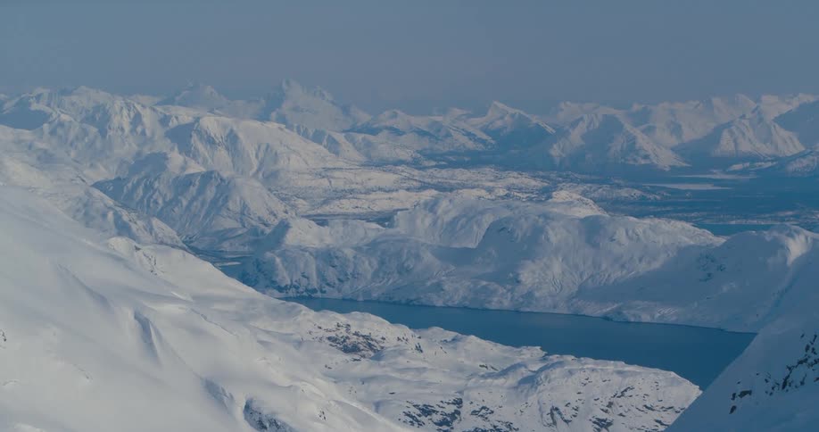 An aerial view of a snow covered mountain is displayed