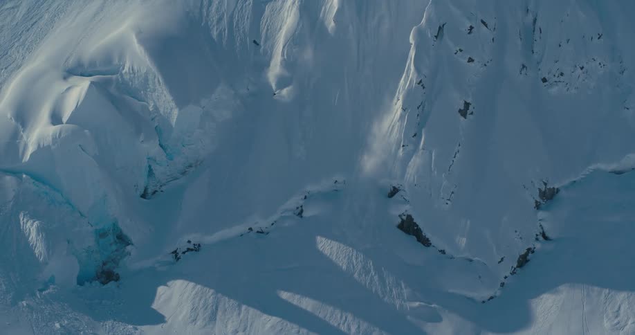 Man skies down the snow covered slopes of a mountain