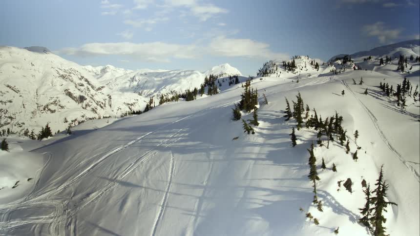 A snowmobile rider rides across a mountain