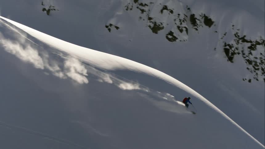 Aerial of a man skiing down a mountain