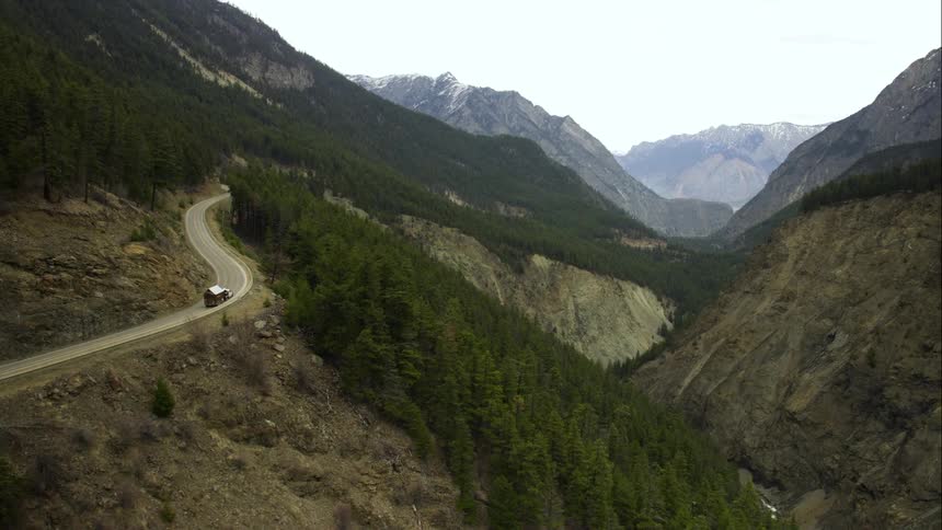 Aerial as a truck drives on a windy mountain road