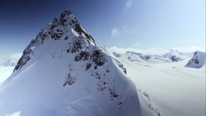 An aerial view of a rocky mountain peak and vast glacier