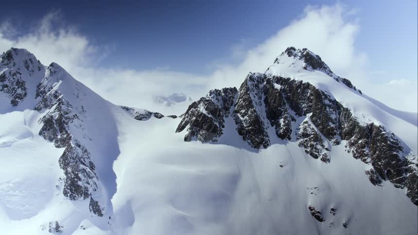 Aerial view of the snow covered peaks of a mountain range at day