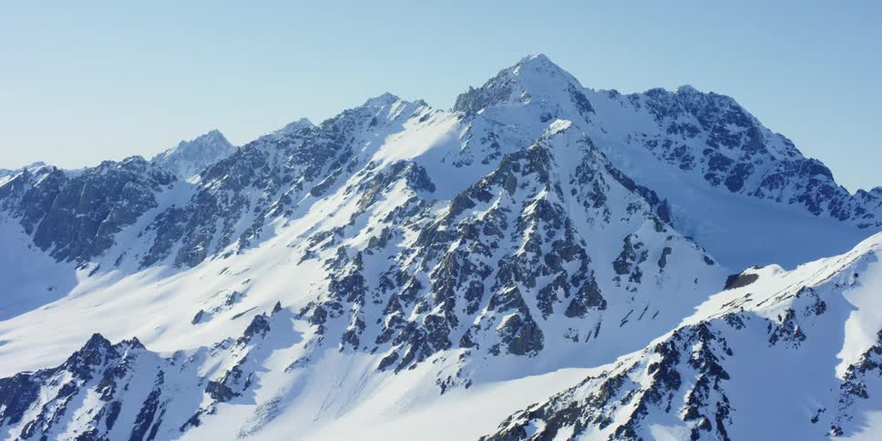Mountain peaks stick out under a layer of heavy snow