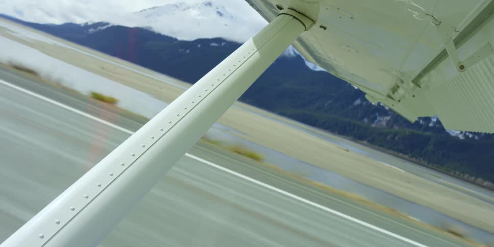 Airplane takes off from airstrip near mountains