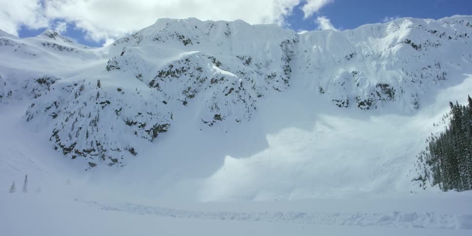 Person riding on snowmobile in front of mountains