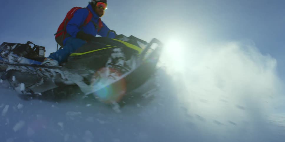 A person on a snowmobile travels on the mountain