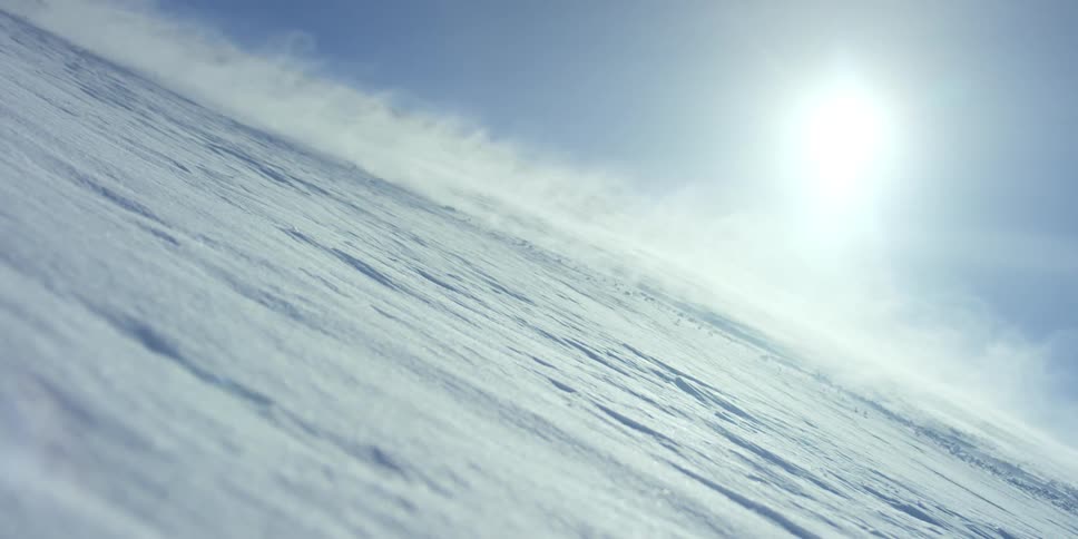 Person rides snowmobile across snow
