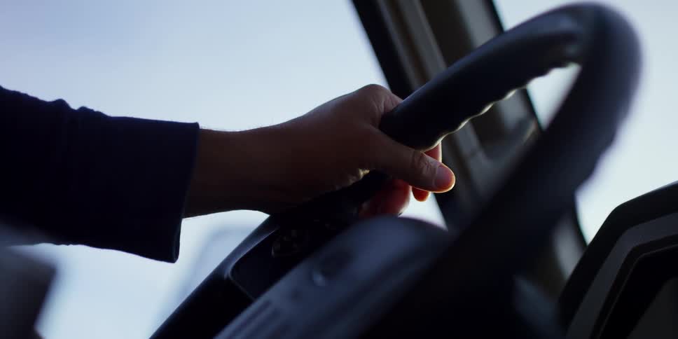 A person is driving a car during midday