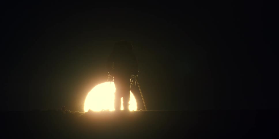 Sun cuts silhouette of a man walking on skis