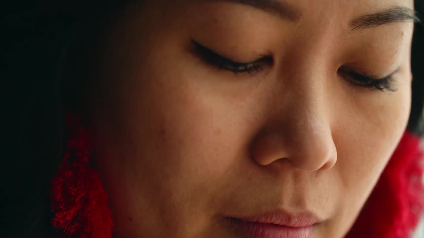 A closeup view of a womans face is displayed
