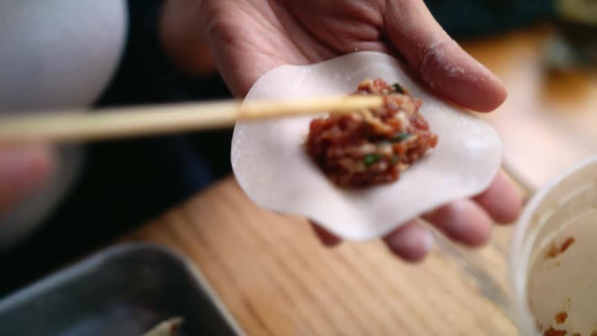 A woman stuffing dumplings