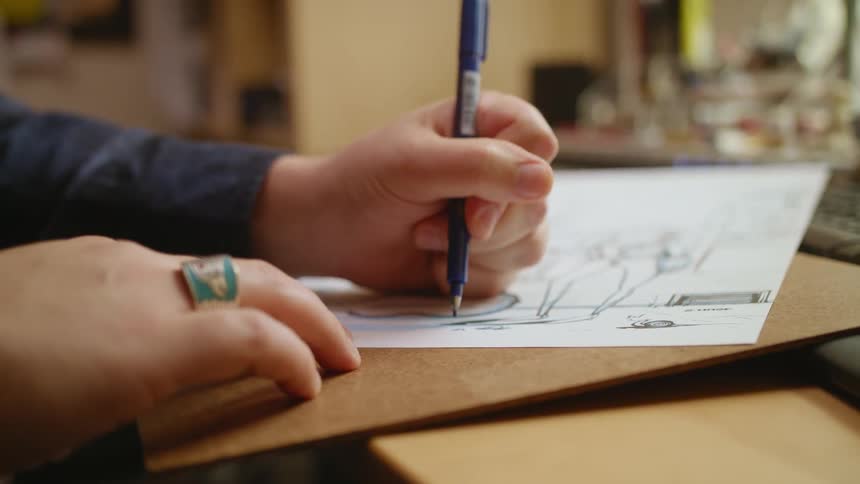A person uses a pen and draws on a piece of paper