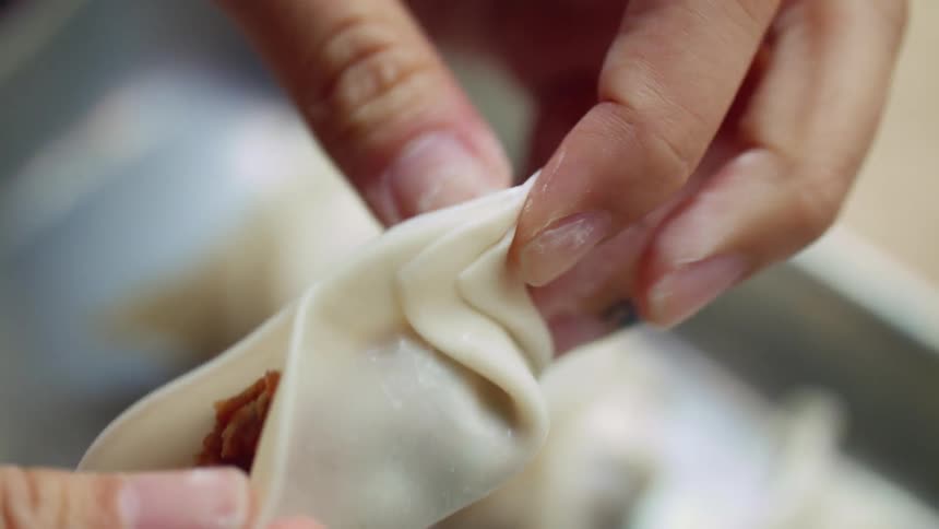A person is preparing dumplings