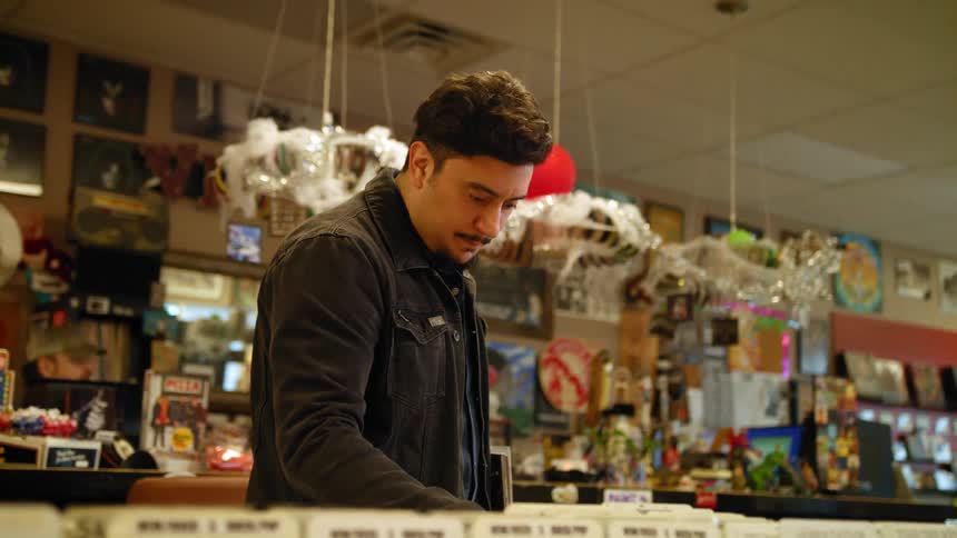 Man browses merchandise in store with his back to counter
