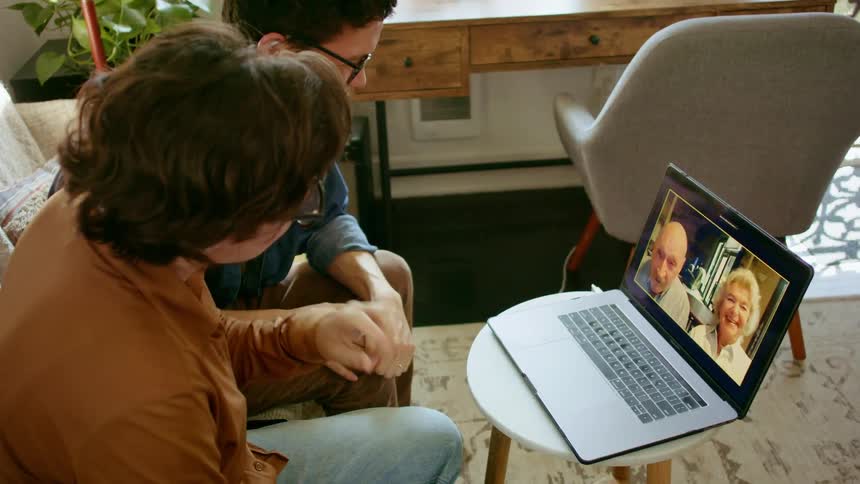 Young couple talks to grandparents in video call