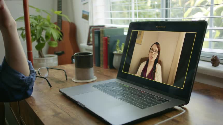 Video call on laptop on desk in home office