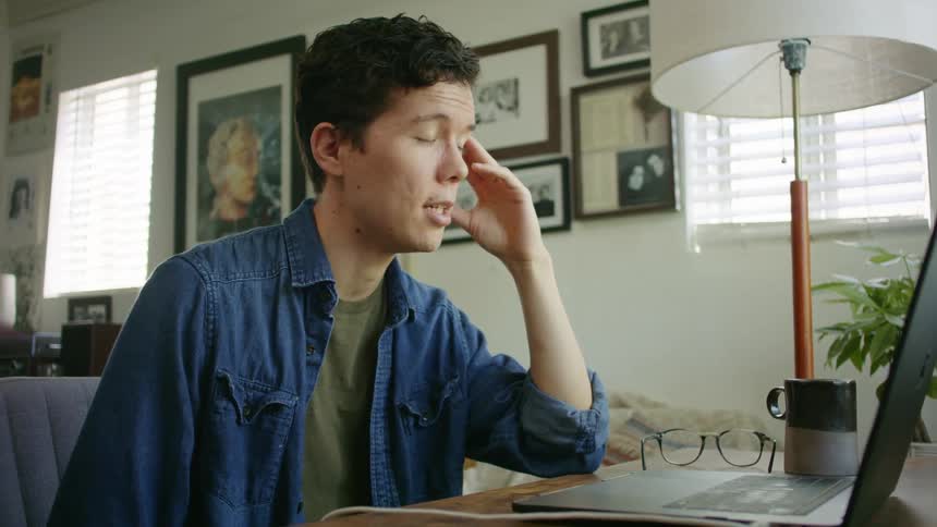 Man sits in front of laptop talking via video call