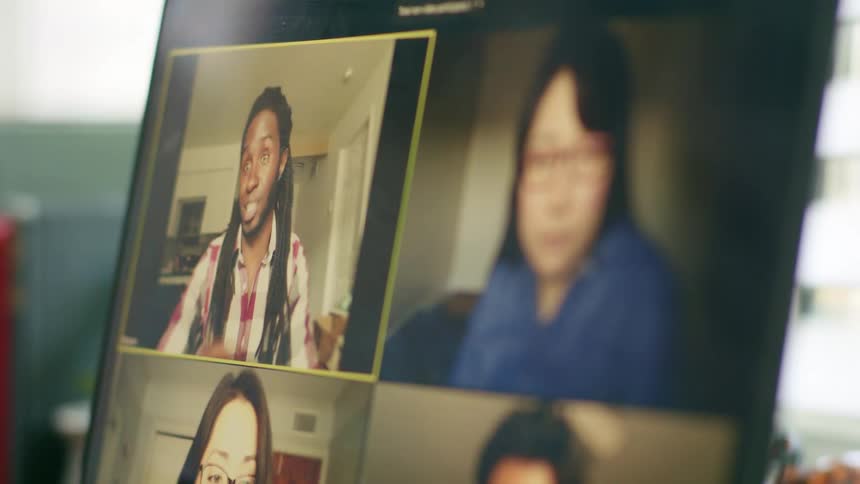 A group of people video chatting on the screen of a laptop