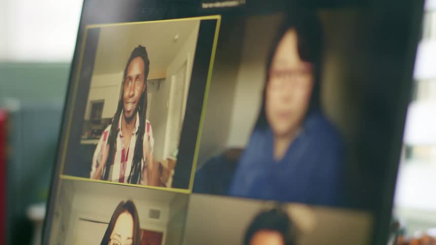 People have a meeting via video call on a laptop