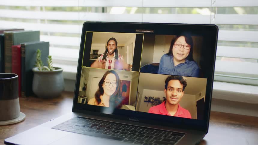 Two men and two woman on a laptop screen participate in a video chat