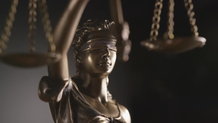 Bronze statue of blindfolded lady justice holds scales