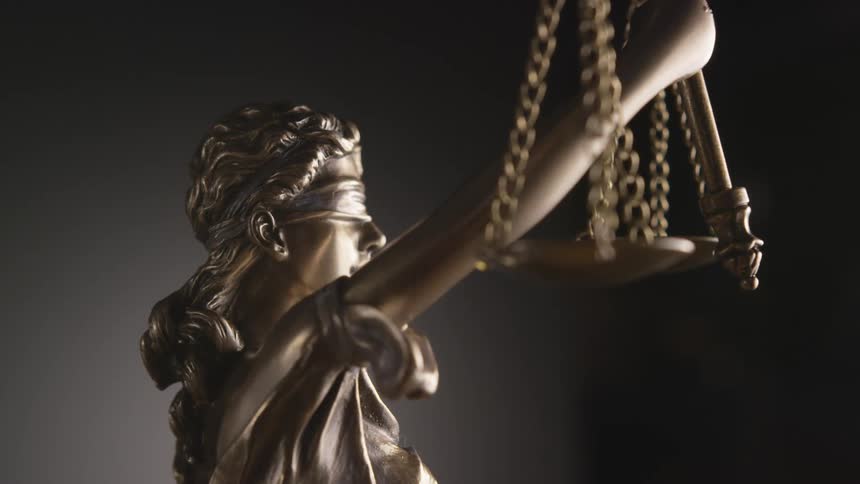 Metal statue of lady justice spinning in a dimly lit room