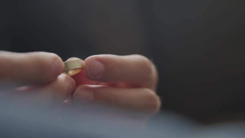 A man is holding a wedding ring