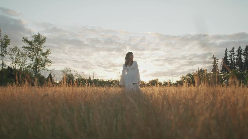 A woman standing in a field of tall grass
