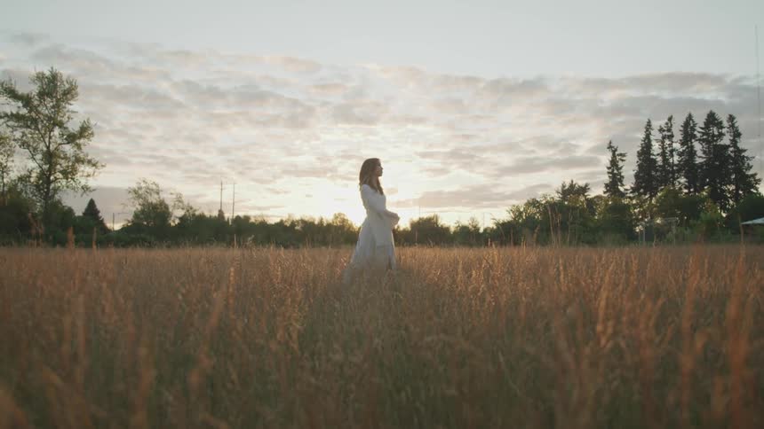 A woman is dancing in a grassland area