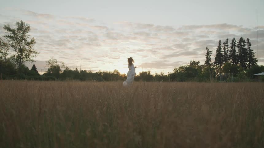 A woman is walking in a rural area at dusk