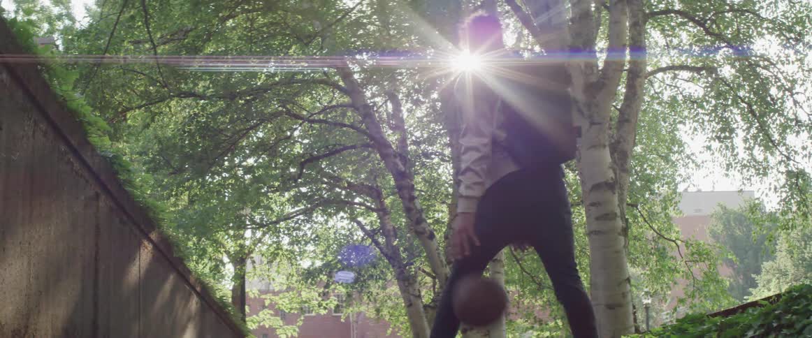A teenage boy dribbles a basketball outside