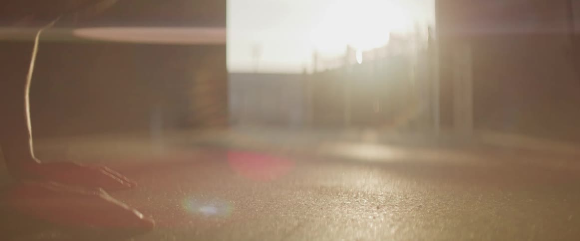 Black man doing push ups is silhouetted against the sunset