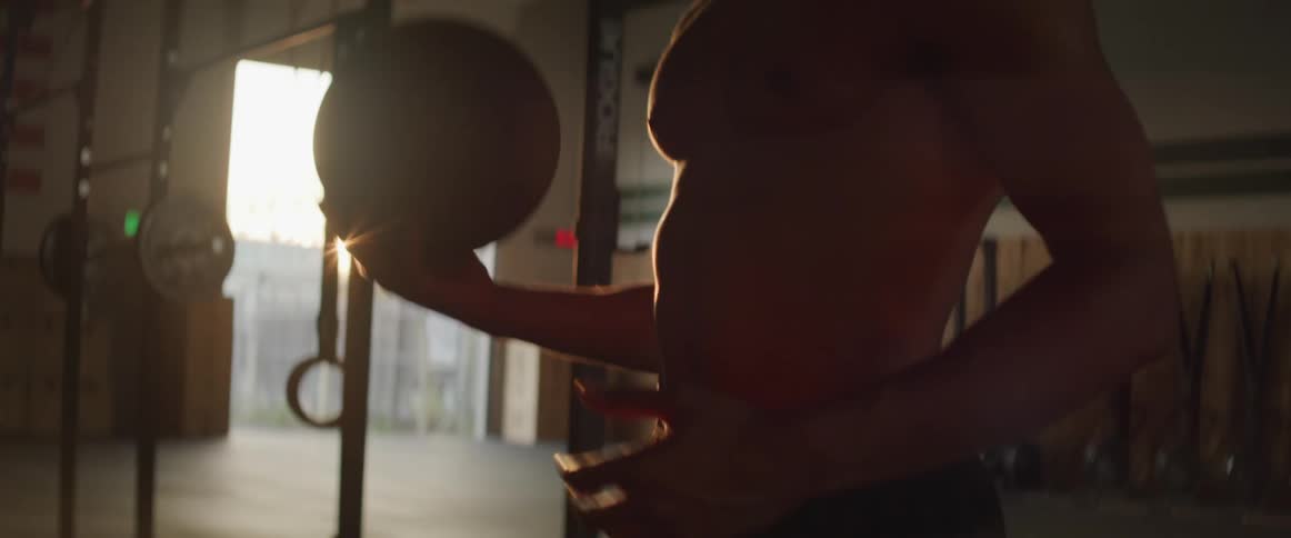 A man is working out in a gym at dusk