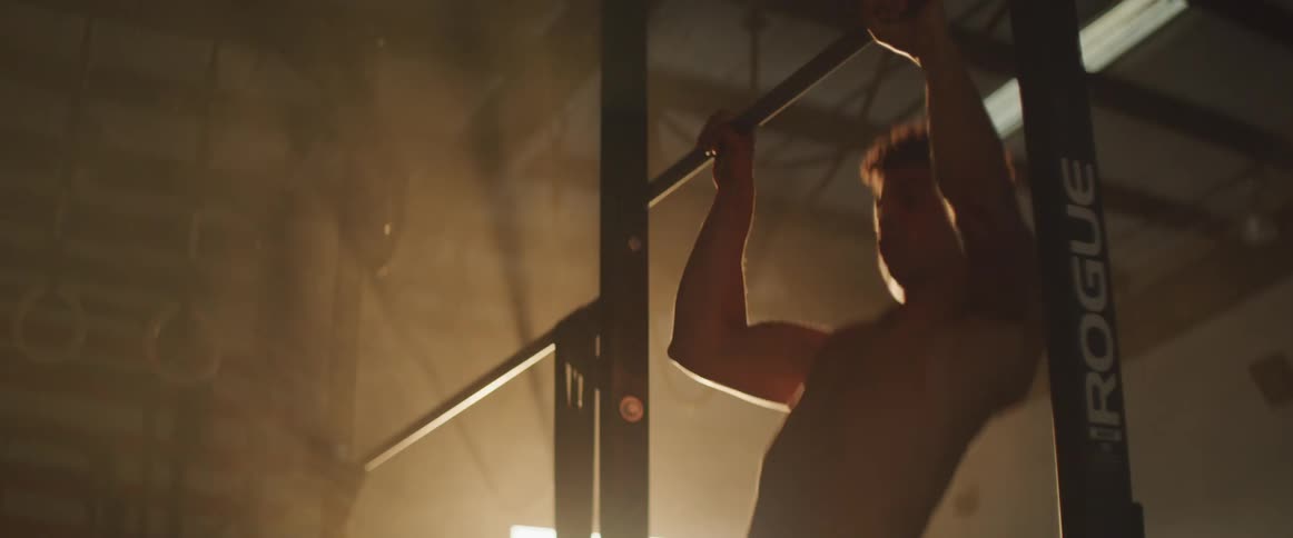 A man is working out in a gym at dusk