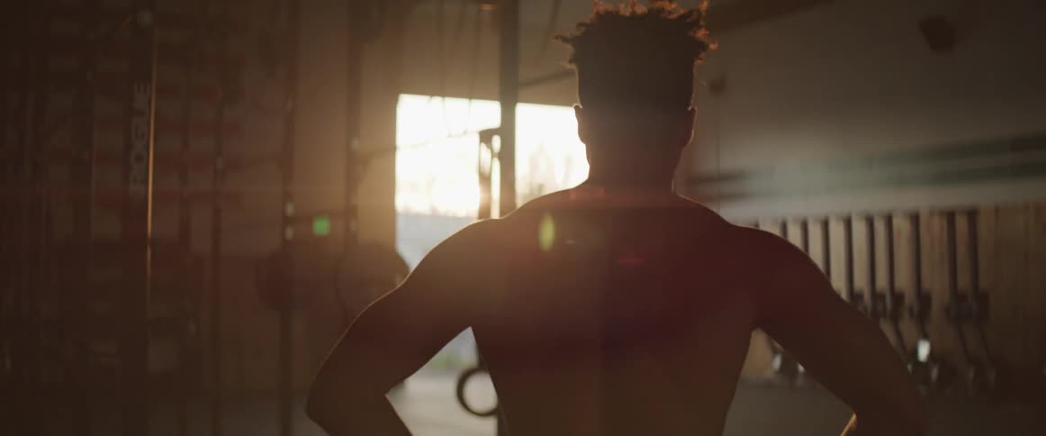 A man is exercising in a gym at dusk