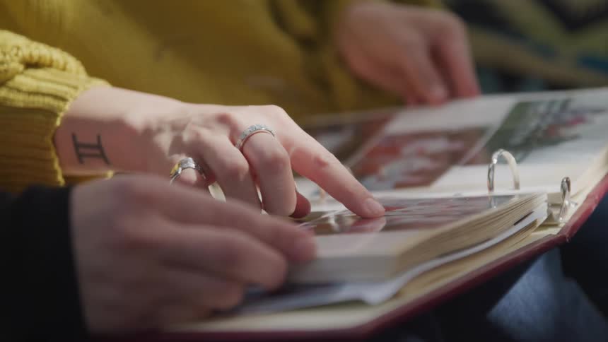 A mother and daughter sit and look at an album filled with photographs