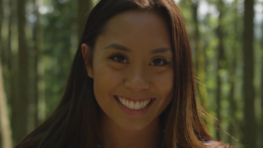 A woman is smiling in a tropical area