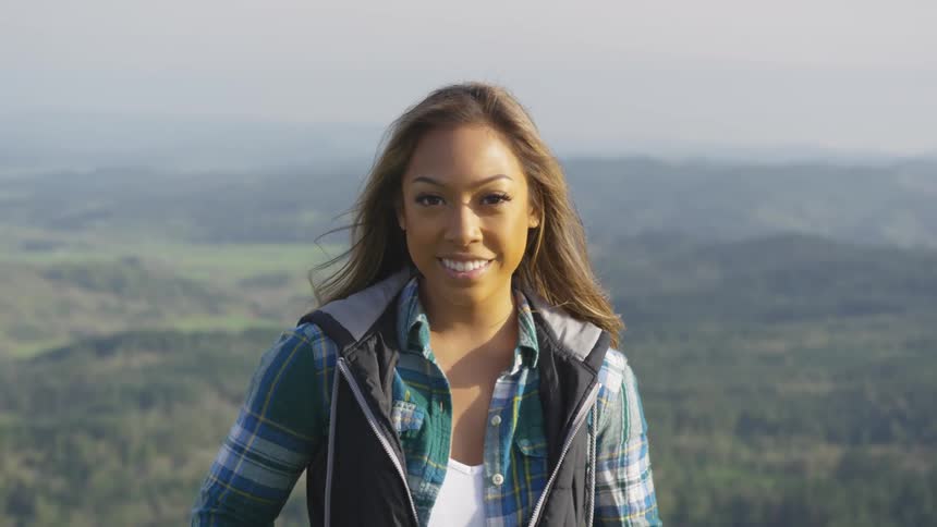 A teenager girl poses for a portrait with the landscape behind her