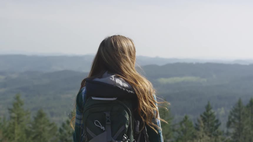 A woman is hiking outdoors in the daytime