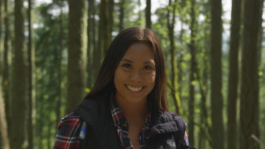 A woman is hiking in a forest area in spring
