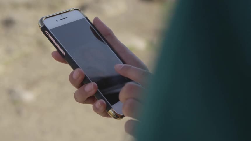 Brunette womans hands use a smartphone